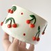 Small milky white crochet yarn holder bowl with red cherries and dots Knitters crocheters